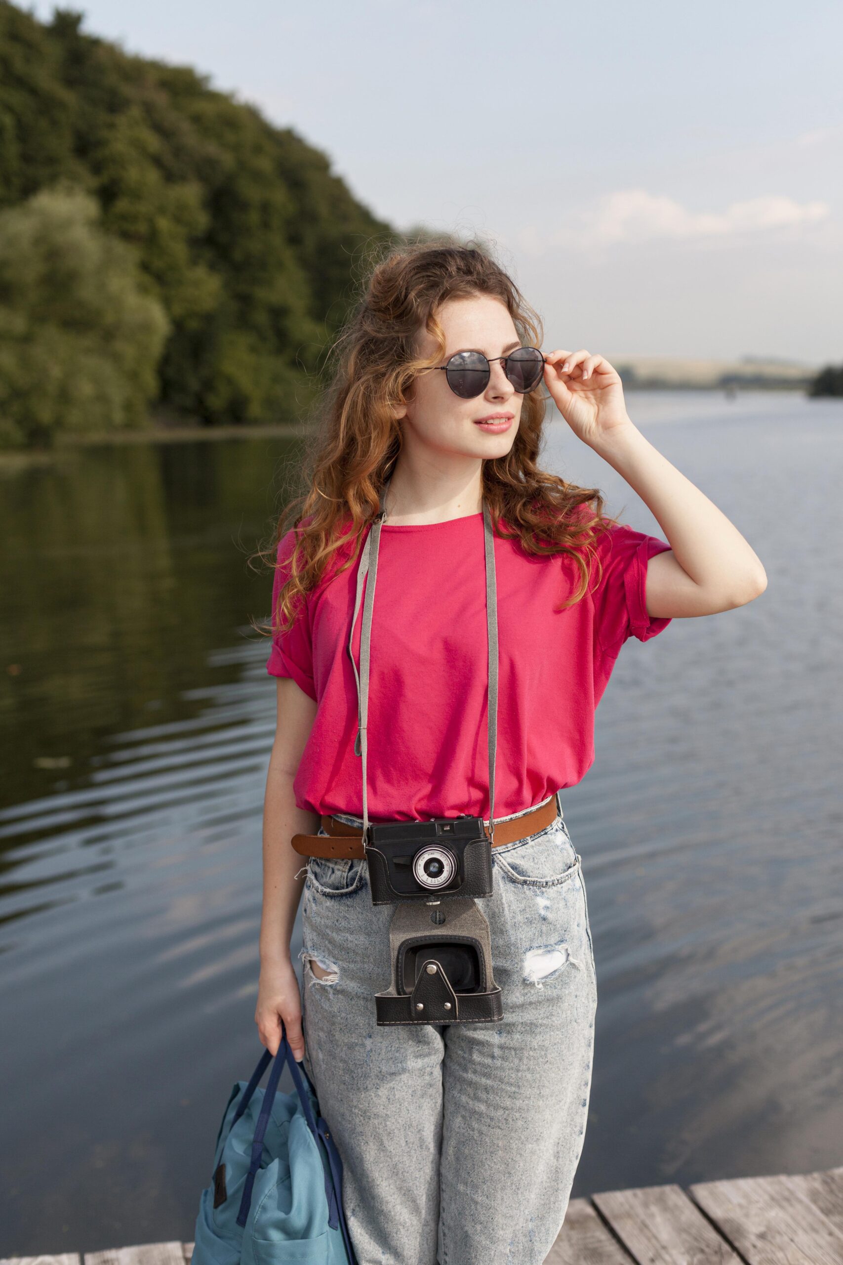 middle-shot-woman-with-camera-posing-front-lake